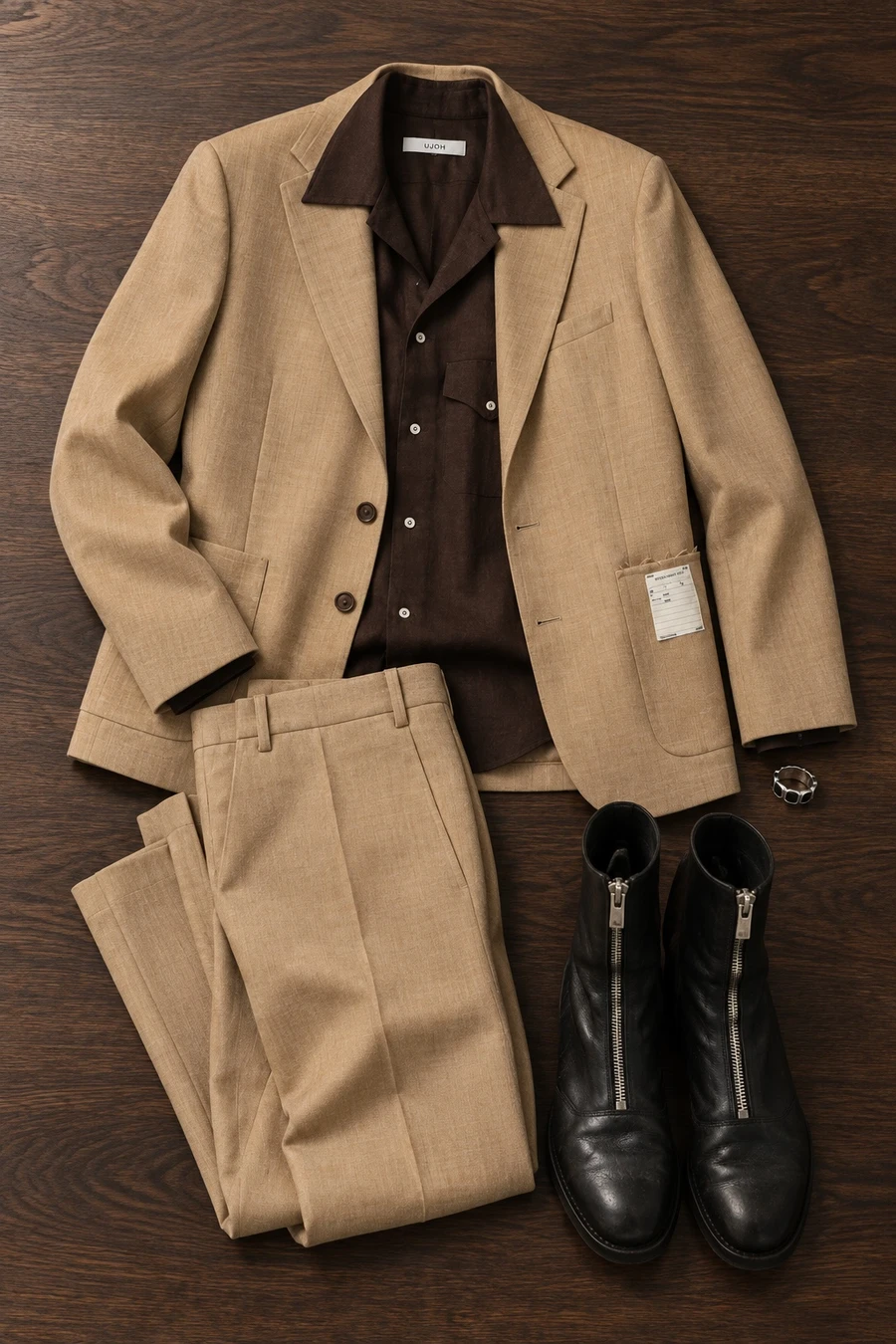A hotel bar, late. Flat lay of a beige MM6 jacket, a chocolate UJOH shirt, beige trousers, black Guidi boots and a Tom Wood ring.