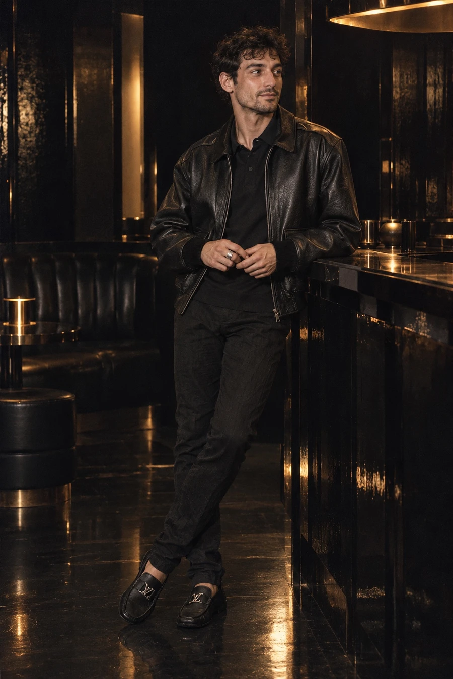 A French man in a black COOR leather bomber, a Sunspel polo, Masnada trousers and Louis Vuitton moccasins stands at a black lacquered bar in Ginza.