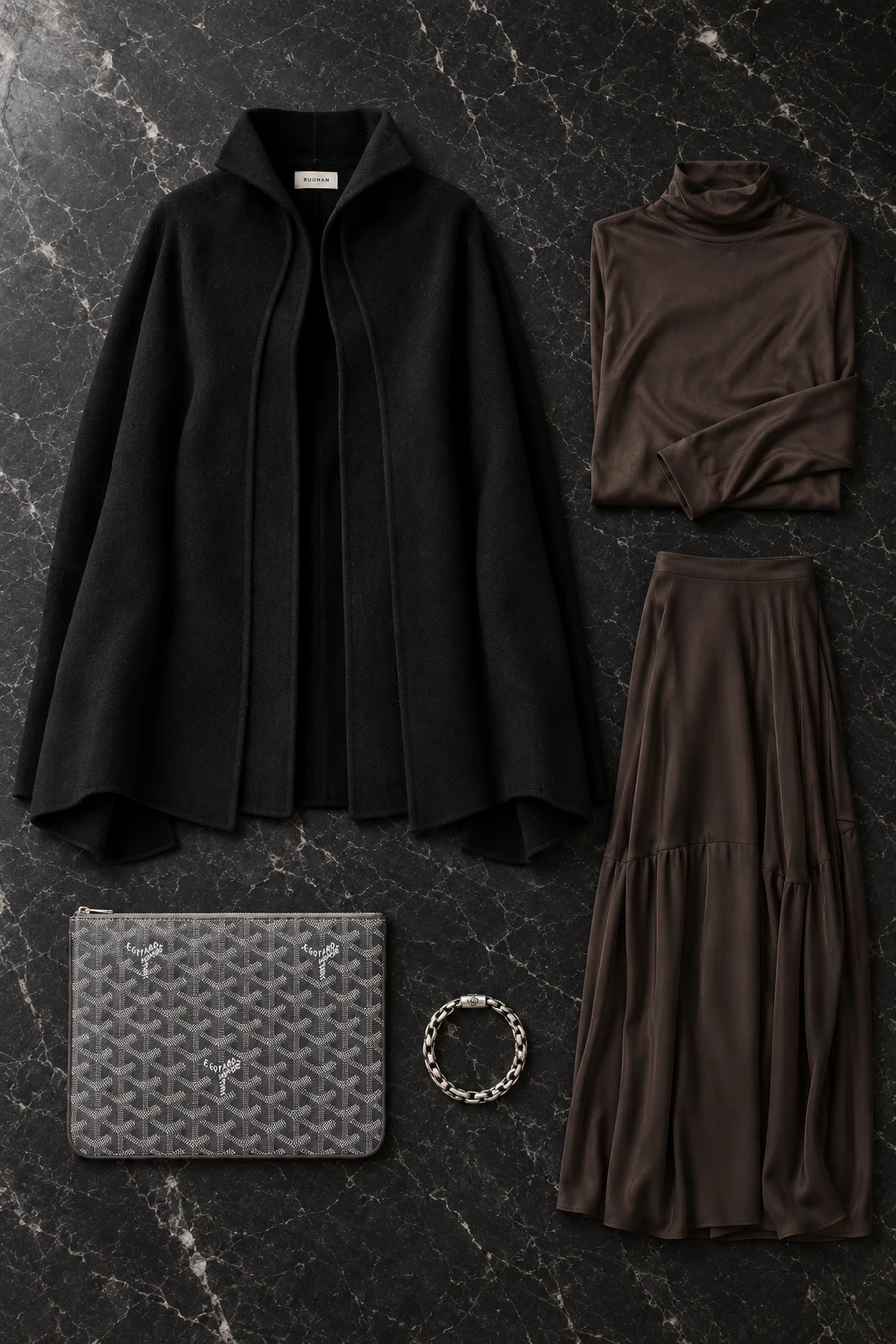 A party at a Doha hotel. Flat lay of an obsidian RUOHAN jacket, a black top, a black skirt and a grey Goyard pouch.