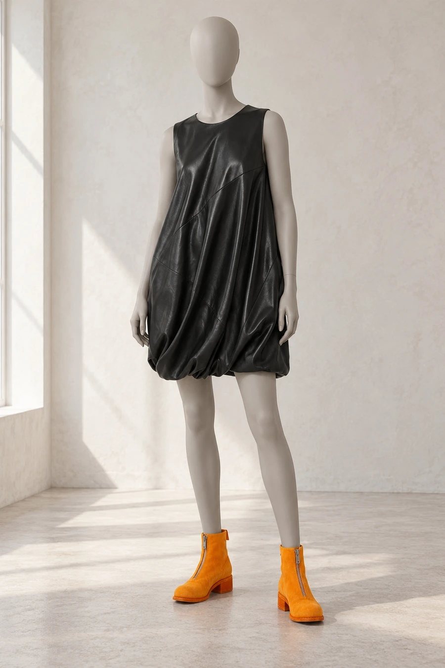 A faceless display mannequin in a Toronto showroom. A black Helmut Lang leather bubble dress meets orange Guidi ankle boots.