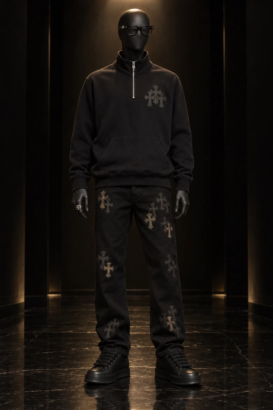 A faceless black mannequin wears a Chrome Hearts quarter zip, cross patch chinos, Rick Owens Temple sneakers, a Cemetery ring and Cox Ucker glasses in a dark gallery room.