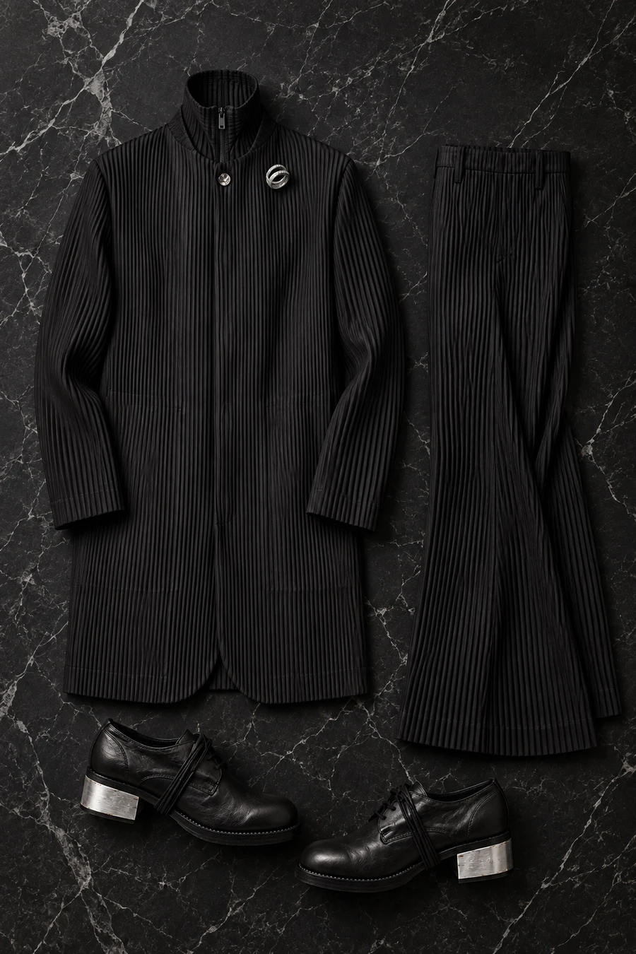 New Year's Eve in New York. Flat lay of a black Issey Miyake jacket, a black sweater, black trousers, black Guidi loafers and a Tom Wood ring.