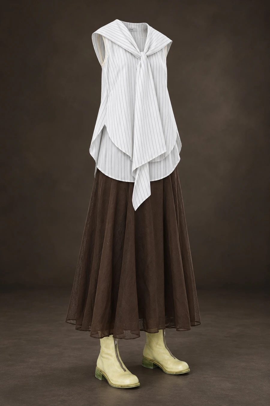 Fine stripes and long UJOH sailor ties fall above an oak brown RUOHAN skirt and kiwi Guidi boots. The complete outfit stands against a dark studio background.