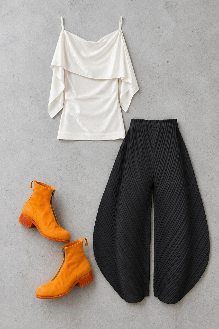 A white MM6 jacquard top, black Pleats Please cocoon trousers and orange Guidi boots.